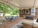 Charming covered patio featuring a dining set, a seating area, and lovely views of the yard and trees at 1325 Marshville Olive Branch Rd, Marshville, NC 28103