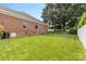 Lush green backyard featuring a spacious lawn, brick home exterior, and mature trees at 133 43Rd Avenue Nw Ln, Hickory, NC 28601