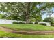 Lush backyard with a mature shade tree, level lawn, and white fencing at 133 43Rd Avenue Nw Ln, Hickory, NC 28601