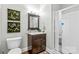 Well-lit bathroom featuring a vanity, walk-in shower, and decorative wall hangings at 133 43Rd Avenue Nw Ln, Hickory, NC 28601