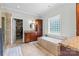 Luxurious bathroom with a soaking tub, tiled floors, granite countertops, and walk-in closet access at 133 43Rd Avenue Nw Ln, Hickory, NC 28601