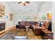 Bright living room featuring a fireplace, a ceiling fan, and a comfortable leather sectional at 133 43Rd Avenue Nw Ln, Hickory, NC 28601