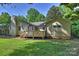 Rear view of the home highlighting deck, chimney, lighting, and a well-manicured lawn at 1522 Barberry Ct, Charlotte, NC 28211