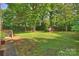 Spacious backyard with a storage shed surrounded by mature trees and lush greenery at 1522 Barberry Ct, Charlotte, NC 28211
