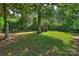 Shaded backyard with a storage shed surrounded by mature trees at 1522 Barberry Ct, Charlotte, NC 28211