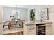 Dining room with modern chandelier, table, chairs, and view of granite countertop and wine cooler at 1522 Barberry Ct, Charlotte, NC 28211