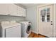 This functional laundry room includes a washer, dryer, and storage cabinets for seamless chore management at 1522 Barberry Ct, Charlotte, NC 28211