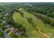 Aerial view of golf course community and homes with mature tree coverage on a sunny day at 15301 Marsh Field Ct, Huntersville, NC 28078
