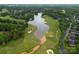 Aerial view of golf course community, featuring lush green fairways, a lake, and mature trees at 15301 Marsh Field Ct, Huntersville, NC 28078