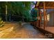 Beautiful stone patio featuring professional hardscapes, landscaping and string lights at 15301 Marsh Field Ct, Huntersville, NC 28078
