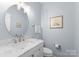 Charming half bathroom features a marble vanity, round mirror, and neutral paint at 15301 Marsh Field Ct, Huntersville, NC 28078