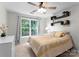 Bedroom with carpet floors, ceiling fan, and large window overlooking the backyard at 15301 Marsh Field Ct, Huntersville, NC 28078
