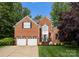 Traditional brick home with a well-manicured lawn, two-car garage, and beautiful curb appeal at 15301 Marsh Field Ct, Huntersville, NC 28078