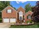 Lovely brick home with a two-car garage, landscaped front yard, and charming front porch and entrance at 15301 Marsh Field Ct, Huntersville, NC 28078
