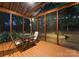 Relaxing screened-in porch with wood flooring, string lights, and an outdoor dining set at 15301 Marsh Field Ct, Huntersville, NC 28078