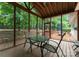 Screened in porch with table and chairs overlooking the beautiful backyard and mature trees at 15301 Marsh Field Ct, Huntersville, NC 28078