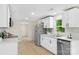 Renovated kitchen with stainless steel appliances, white cabinets, and modern countertops, open to the living space at 1574 Mangum Dr, Lancaster, SC 29720