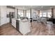 Open-concept kitchen with a large island, stainless steel appliances, and hardwood floors flowing into the living area at 1600 Baymont Ct, Stanley, NC 28164