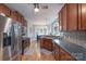 Bright kitchen with stainless steel appliances, wooden cabinets, and an adjoining dining area at 1643 Essex Hall Dr, Rock Hill, SC 29730