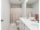 Bright bathroom featuring dual sinks, a spacious countertop, and a shower with a stylish, neutral-toned curtain at 17812 New Mark Ave, Charlotte, NC 28278
