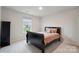 A cozy bedroom features a black bed frame with stylish bedding, complemented by a window with a view of the neighborhood at 17812 New Mark Ave, Charlotte, NC 28278