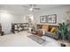 Upstairs living room featuring gray sofa with stylish pillows, a modern fan, decor, and adjacent seating at 17812 New Mark Ave, Charlotte, NC 28278