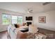Spacious living room with television mounted over fireplace, neutral sofa, and natural light at 17812 New Mark Ave, Charlotte, NC 28278