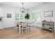 Dining area featuring a wood table, white chairs, modern chandelier, and a view of the outdoor patio at 182 Mackenzie Ct, China Grove, NC 28023