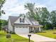View of the front of a well-manicured home, featuring a driveway, two-car garage, and landscaped front yard at 182 Mackenzie Ct, China Grove, NC 28023