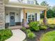 Inviting front porch with stone pillars, decorative wreath, and lush landscaping creates a welcoming entrance at 182 Mackenzie Ct, China Grove, NC 28023