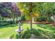 Lush backyard with a well-maintained lawn, fountain, and mature trees providing shade at 19539 Denae Lynn Dr, Cornelius, NC 28031