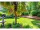 Beautiful backyard featuring a well-manicured lawn, fountain, and mature landscaping at 19539 Denae Lynn Dr, Cornelius, NC 28031