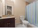 Cozy bathroom featuring a shower with curtain and dark cabinets with a granite countertop at 1974 Glen Manor Ct, Lincolnton, NC 28092