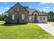 Beautiful stone and brick home featuring an arched doorway, two-car garage, and lush green lawn at 1974 Glen Manor Ct, Lincolnton, NC 28092