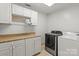 Bright laundry room featuring modern washer and dryer, ample cabinet space, and granite countertops at 1974 Glen Manor Ct, Lincolnton, NC 28092