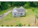 Aerial view of a cozy home with a charming front porch, complemented by a lush green yard and surrounding trees at 2126 Robby Dr, Maiden, NC 28650