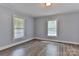 Well-lit bedroom with hardwood floors and soft-blue walls, brightened by two windows at 2126 Robby Dr, Maiden, NC 28650