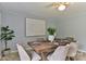 Elegant dining room with a wooden table set for six, illuminated by a modern ceiling fan and natural light at 2126 Robby Dr, Maiden, NC 28650