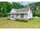 Cozy house with covered porch, chairs, landscaped yard and mature trees at 2126 Robby Dr, Maiden, NC 28650