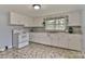 Well-lit kitchen with white cabinets and a window providing a view, offering a clean cooking space at 2126 Robby Dr, Maiden, NC 28650