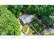 Charming home with lush greenery, features a brick exterior, well-manicured lawn, and inviting walkway, nestled among mature trees at 220 Pinehurst Ln, Newton, NC 28658