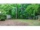 Backyard view featuring a shed, woodpile, fencing and mature trees at 220 Pinehurst Ln, Newton, NC 28658