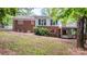 Exterior view of brick home with deck, walk out porch, fenced yard and mature landscaping at 220 Pinehurst Ln, Newton, NC 28658