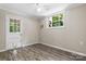 Bedroom with wood floor and window and white door leading outside with a pet door at 220 Pinehurst Ln, Newton, NC 28658