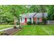 Traditional brick home with a red door and white trim is set amidst a lush green lawn and mature trees at 220 Pinehurst Ln, Newton, NC 28658