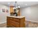 Kitchen island featuring wooden cabinetry, granite counters, and modern lighting at 220 Pinehurst Ln, Newton, NC 28658