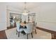 This dining room features a chandelier, hardwood floors, and views into the living spaces at 2445 Selwyn Ave # 104, Charlotte, NC 28209