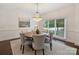 Dining area features hardwood floors, a chandelier, and natural light from a nearby window at 2445 Selwyn Ave # 104, Charlotte, NC 28209