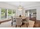 Dining area features hardwood floors, a chandelier, and natural light from a nearby window at 2445 Selwyn Ave # 104, Charlotte, NC 28209
