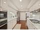 Bright kitchen featuring white cabinetry, countertops, and modern appliances, all complemented by warm hardwood floors at 2445 Selwyn Ave # 104, Charlotte, NC 28209